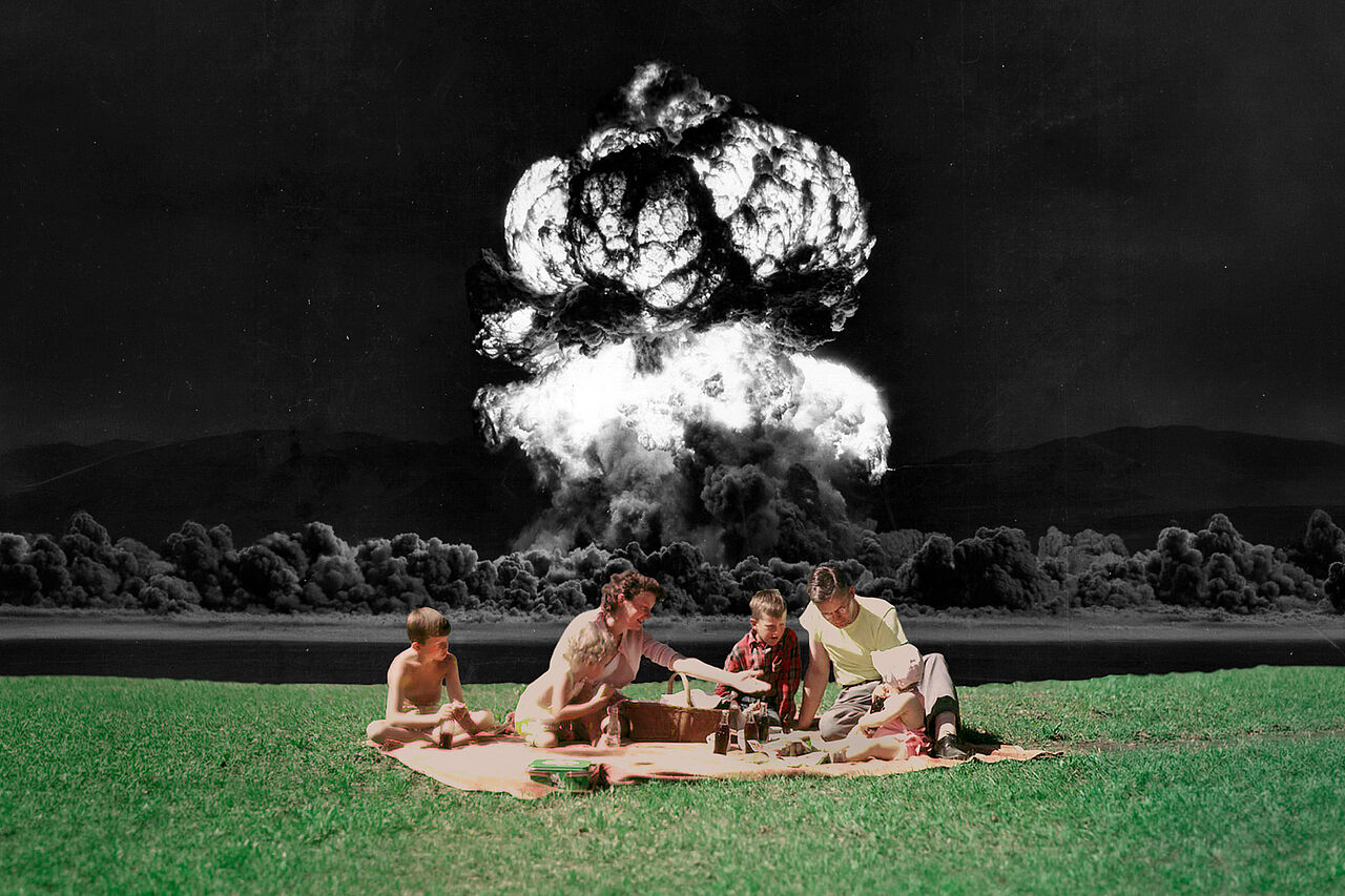 Collage aus zwei Bildern: Im Vordergrund sitzt eine Familie aus den 1950er/60er Jahren auf einer Picknick-Decke, während im Hintergrund ein schwarz-weißer Atompilz in die Höhe steigt.